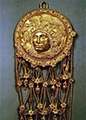 Щиток серьги с рельефным изображением головы Афины в шлеме из погребения в кургане Куль-Оба. Золото. Начало IV века до н.э. ГЭ